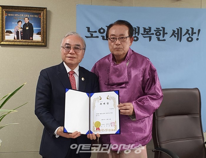 대한노인회 김호일 회장이 박상원 박사에게 고문 추대장을 수여하고 기념사진을 찍고있다.