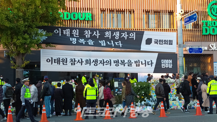 지난달 29일 밤 서울시 중구 이태원 일대에서 발행한 할로윈 축제 사고 현장에서 시민들이 사고로 희생된 분들을 위한 조문을 하고 있다. 국민의 힘과 더불어민주당에서 내걸은 현수막이 눈에 보인다. 2022.11.05 사진 ⓒ아트코리아방송 이용선 기자​