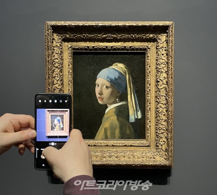 요하네스 베르메르의 유명한 진주 귀걸이를 한 소녀를 촬영하는 미술 평론가 . 사진-비비안 차우.