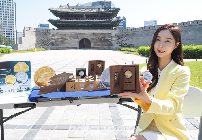 625년의 역사를 지닌 '국보 숭례문'의 기념메달 행사가 8일 오전 서울 중구 세종대로 숭례문 앞에서 진행되었다. 모델이 '국보 숭례문; 기념 메달을 들고 포즈를 취하고 있다. 2023.05.08 사진  ⓒ아트코리아방송 이용선 기자​