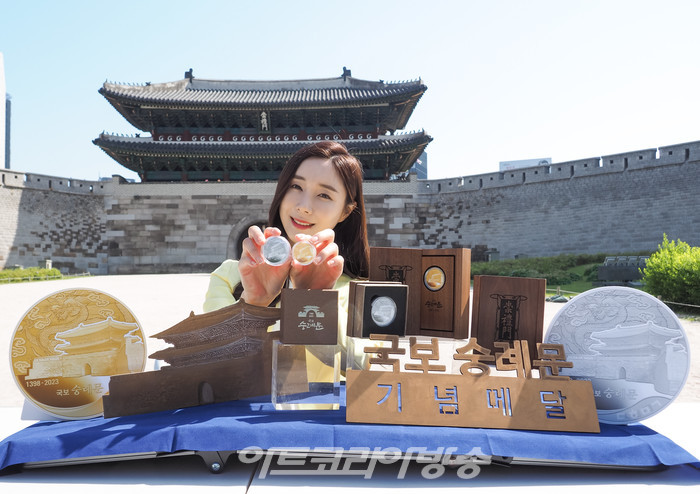 625년의 역사를 지닌 '국보 숭례문'의 기념메달 행사가 8일 오전 서울 중구 세종대로 숭례문 앞에서 진행되었다. 모델이 '국보 숭례문; 기념 메달을 들고 포즈를 취하고 있다. 2023.05.08 사진 ⓒ아트코리아방송 이용선 기자​
