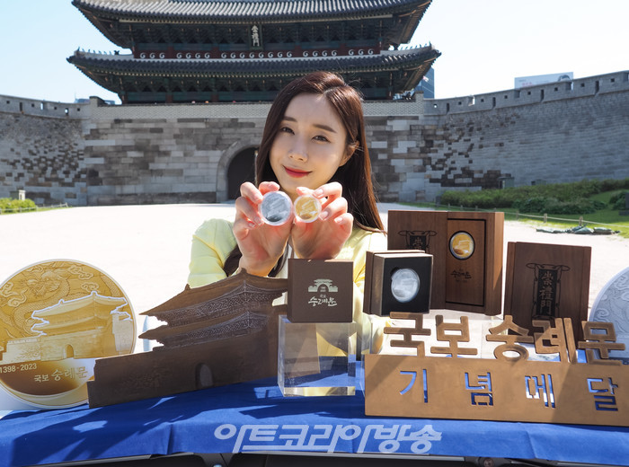 625년의 역사를 지닌 '국보 숭례문'의 기념메달 행사가 8일 오전 서울 중구 세종대로 숭례문 앞에서 진행되었다. 모델이 '국보 숭례문; 기념 메달을 들고 포즈를 취하고 있다. 2023.05.08 사진 ⓒ아트코리아방송 이용선 기자​