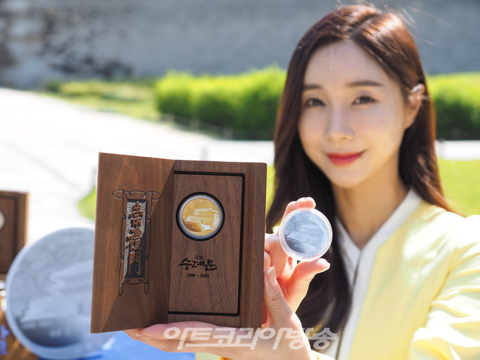 625년의 역사를 지닌 '국보 숭례문'의 기념메달 행사가 8일 오전 서울 중구 세종대로 숭례문 앞에서 진행되었다. 모델이 '국보 숭례문; 기념 메달을 들고 포즈를 취하고 있다. 2023.05.08 사진 ⓒ아트코리아방송 이용선 기자​