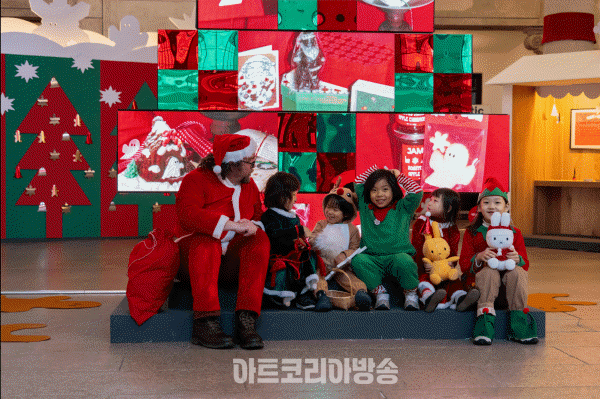 중앙홀에서 산타와 사진 찍는 어린이들