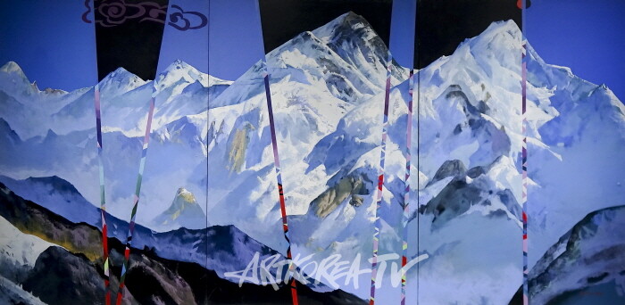 히말라야의 축제-Festival in the Himalaya. 2008-333.3×248.5cm 캔버스에 유채 Oil on canvas'히말라야의 축제' (2008)은 최예태의 초기 대작으로, 히말라야의 광대한 풍경을 모티프로 삼아 색면 분할과 두터운 터치로 화면을 조밀하게 구성 한다. 특히 화면 곳곳에 삽입된 색띠와 한국적 문양은 이국적 풍경 속에 작가의 정체성을 병치하며, 전통과 현대, 한국성과 세계성을 교차시키는 장치로 기능한다.Festival of the Himalayas (2008), one of Choi Yetae's early large-scale works, reconfigures the vast mountain landscape through bold divisions of color and dense brushwork. Inserted bands and Korean motifs intersect tradition and modernity, local identity and global imagery.-사진촬영 최윤영 기자