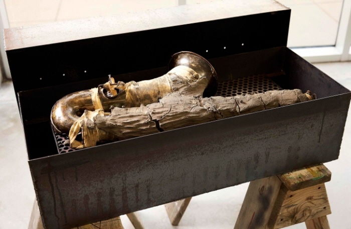 자말 사이러스,  '혼 빔 성찬', 2025. 톱질대, 맞춤 제작 강철 및 목재 훈연기, 테너 색소폰, 거즈, 미시시피 강 진흙, 모자반, 철도 못, 경목 숯, 체리나무와 히코리나무 조각, 미시시피 강물 잔여물, 알로에, 트윙클 실버 광택제, 우드, 유향과 몰약, 90.8 x 106.7 x 65.4cm. 작가 및 후원사 제공, 로스앤젤레스